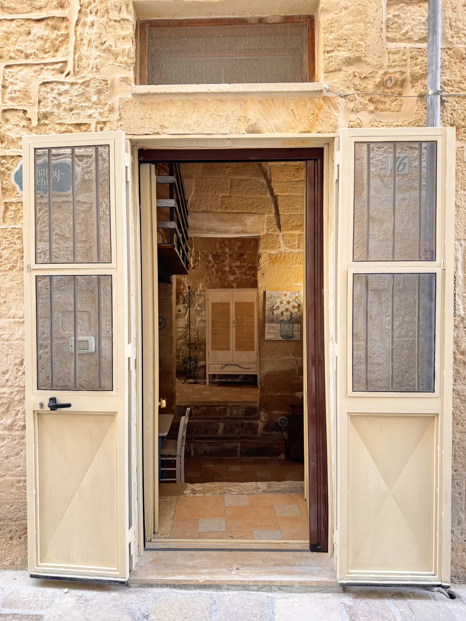Porta di ingresso aperta di Boemondo House sulla facciata in pietra