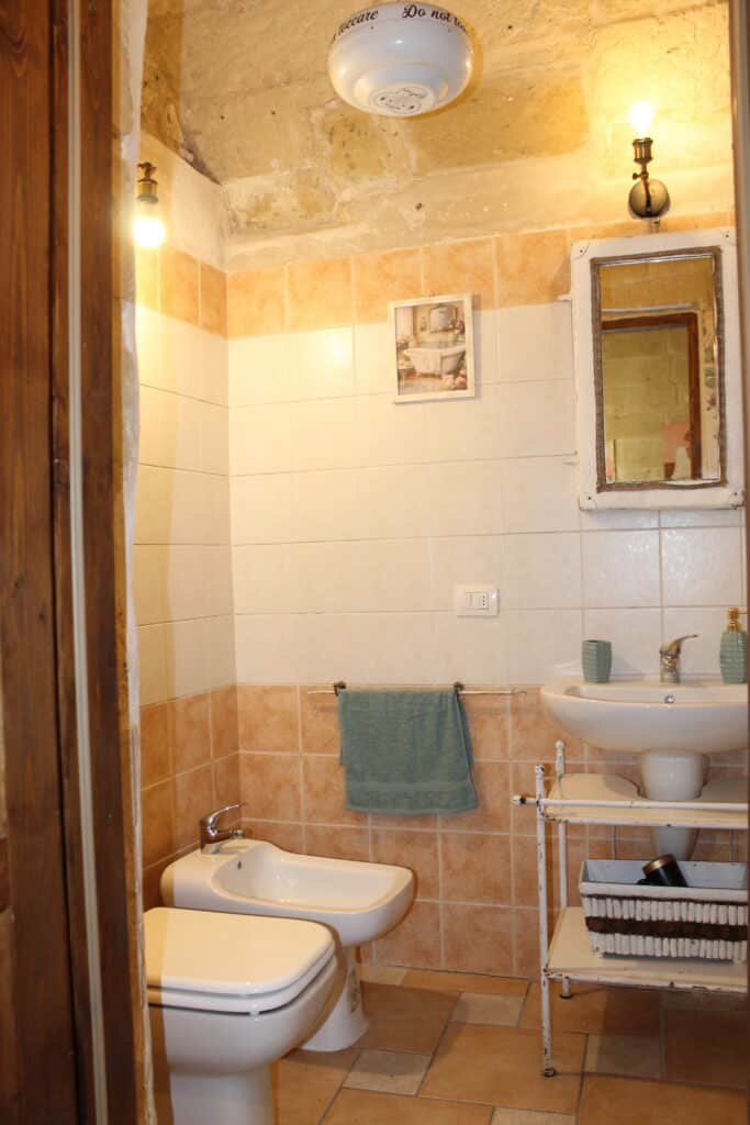Bagno con lavabo, specchio e sanitari di Boemondo House