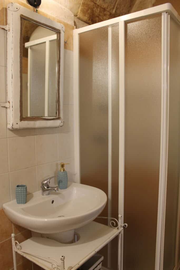 Lavabo con specchio e cabina doccia nel bagno di Boemondo House