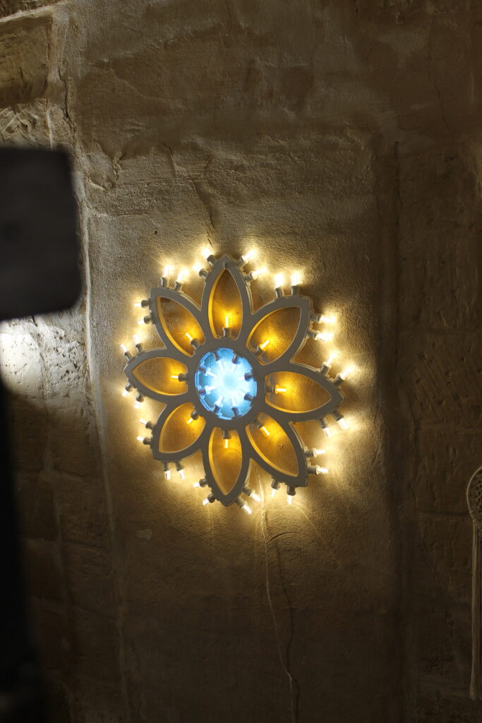 Dettaglio della luminaria a rosone con luci gialle e blu di Boemondo House
