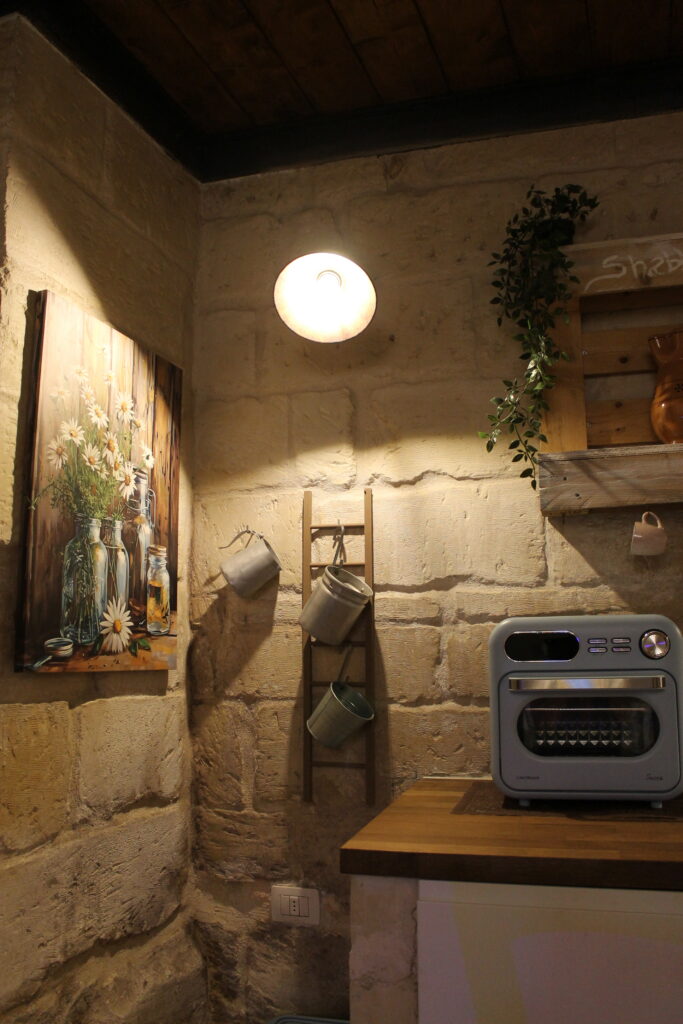 Forno e mensole della cucina con pareti in pietra di Boemondo House