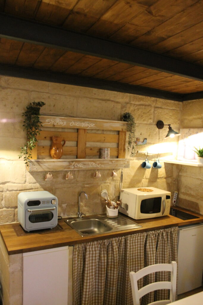 Angolo cucina con elettrodomestici e pareti in pietra di Boemondo House