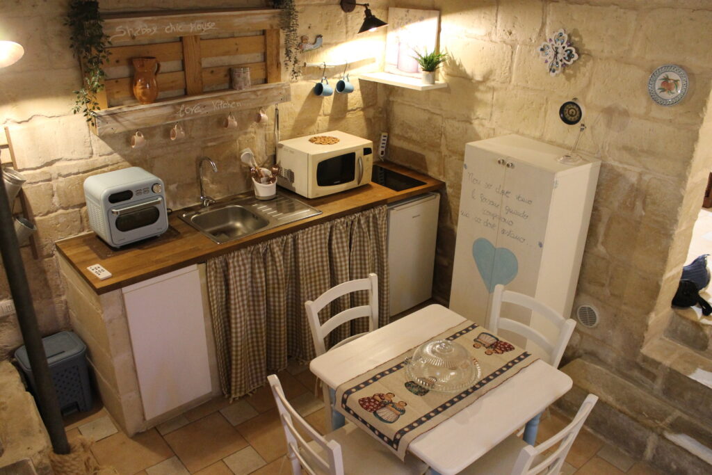 Cucina con lavello, microonde e tavolo da pranzo di Boemondo House