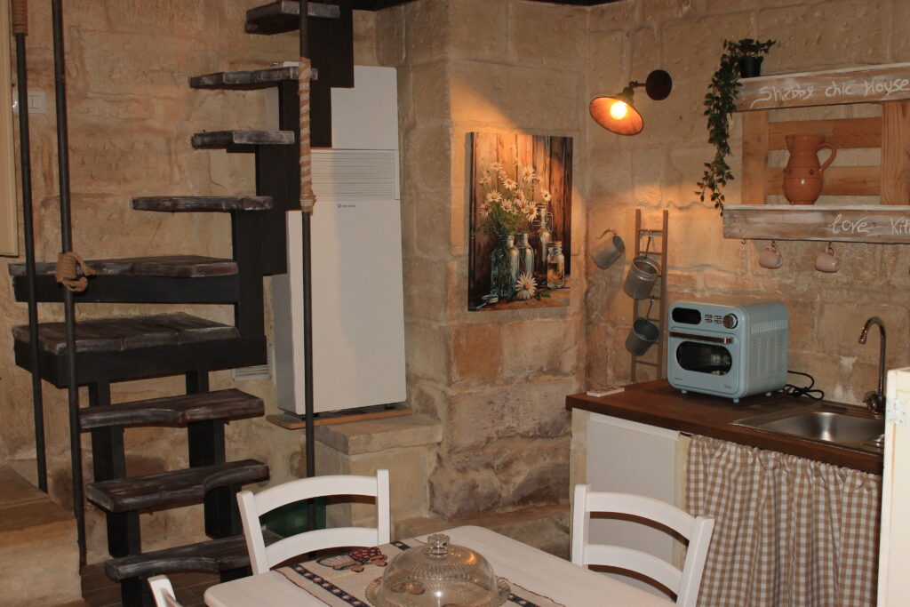 Tavolo da pranzo, frigorifero e scala a chiocciola di Boemondo House